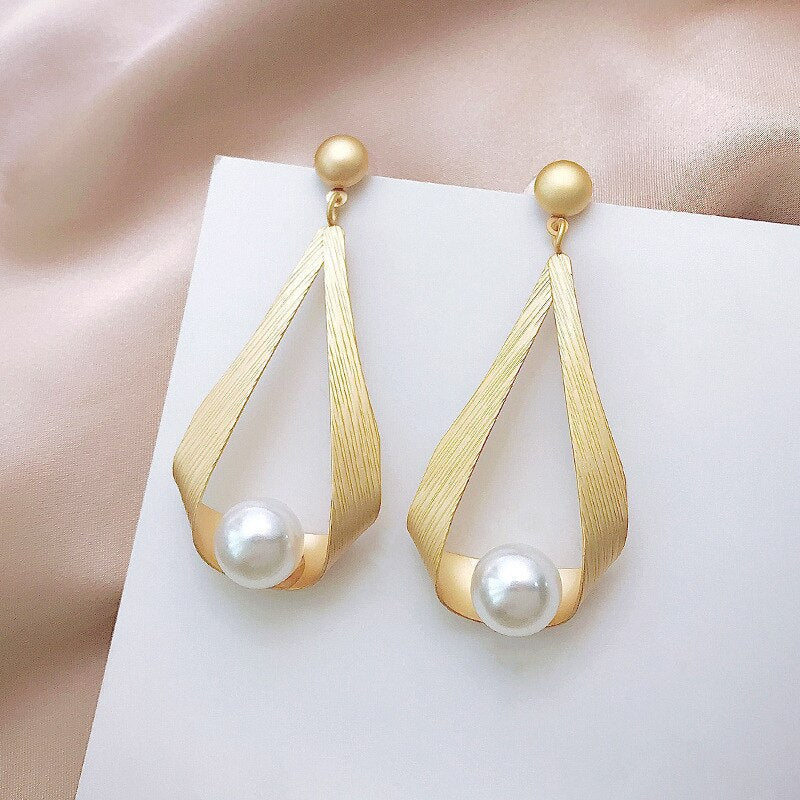 Elegante gouden druppelvormige oorbellen met parels