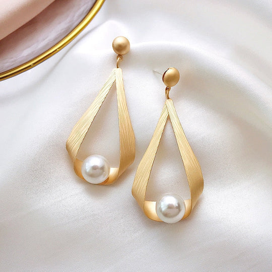 Elegante gouden druppelvormige oorbellen met parels